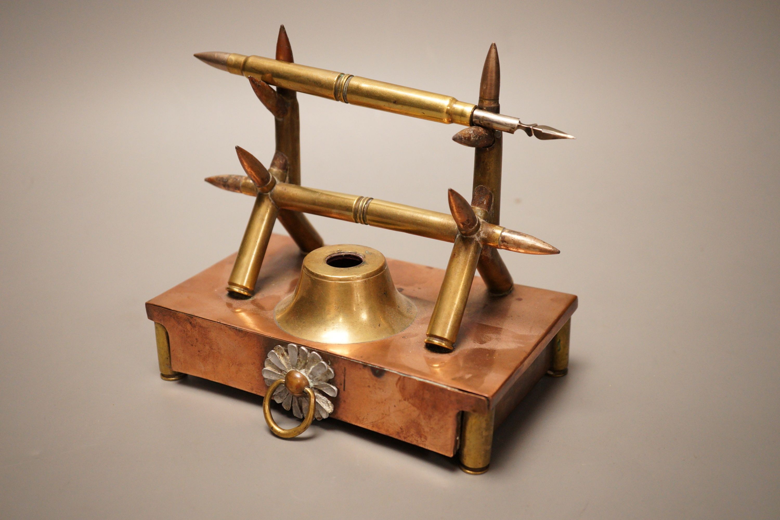 A copper and brass Trench art desk stand, 16cm wide